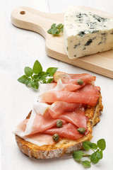Sandwich with rye bread with aromatic, smoked ham and capers