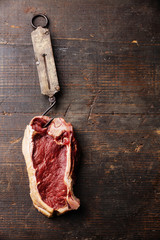 Raw fresh meat Ribeye Steak and vintage steelyard on dark backgr