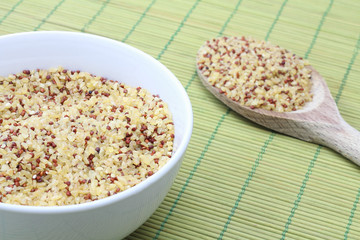 Bulgur in white bowl and wooden spoon