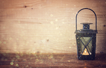 vintage Lantern with burning candles, pine cones on wooden table