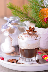 Winter whipped cream hot coffee in a glass cup with anise and
