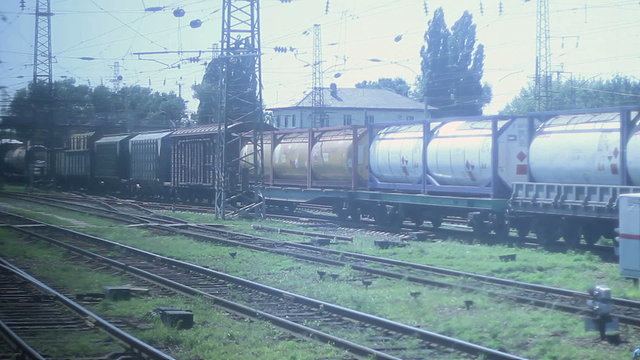 Looking through coach window, freight trains industrial district