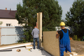 Workmen erecting wall insulation panels