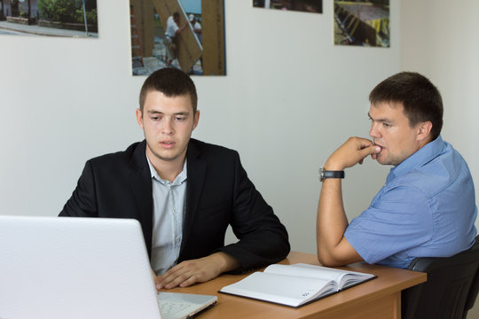 Young Businessmen Looking at Computer Seriously