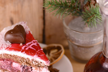 pieces of cake on wooden background with flowers and carafe