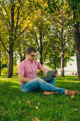 Young man Working in the Park with Laptop Computer