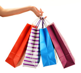 Female hand holding paper shopping bags isolated on white