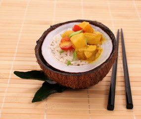 oconut with rice and curry chicken on bamboo background