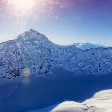 Mountain peak at Swiss Aletch glacier helicopter view in winter