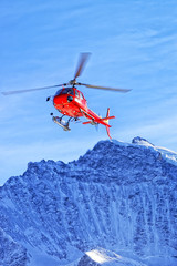 Fototapeta na wymiar Red helicopte rat swiss alps near Jungfrau mountain