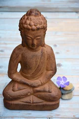 Foto auf Acrylglas Boeddha standbeeld op oud houten achtergrond met Zen stenen © trinetuzun