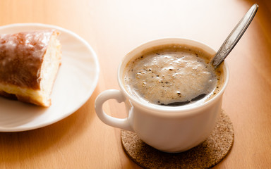 Beverage and sweet food. Cup of coffee and bun.