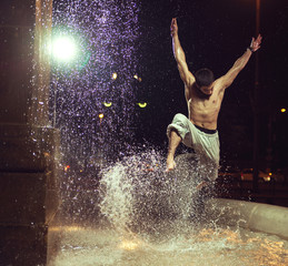 Obraz na płótnie Canvas Muscular man jumping in fountain