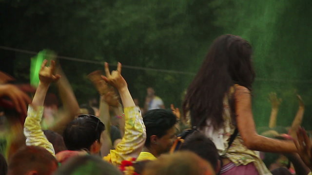 People throw colorful paint in the air at festival, celebration