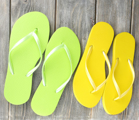Color flip-flops on wooden board, isolated on white