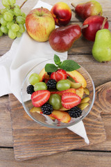 fresh tasty fruit salad on wooden table
