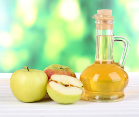 Apple cider vinegar in glass bottle and ripe fresh apples,