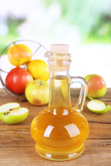 Apple cider vinegar in glass bottle and ripe fresh apples,