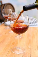 Red wine pouring into wine glass, close-up