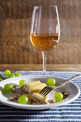 beautiful still life with wine, cheese and ripe grape