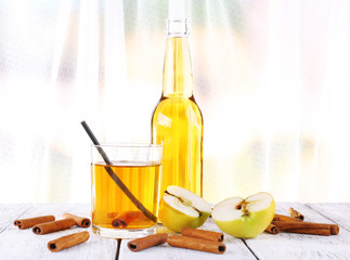 still life with apple cider and fresh apples on wooden table