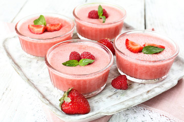 Delicious berry mousse in bowls on table close-up