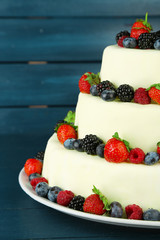 Beautiful wedding cake with berries on  dark wooden background