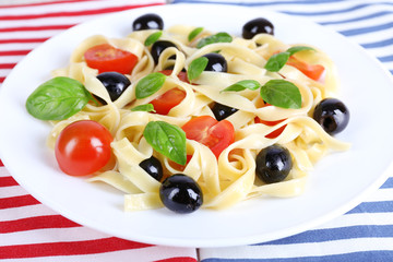 Spaghetti with tomatoes, olives and basil leaves