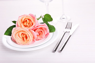 Table setting with pink rose on plate