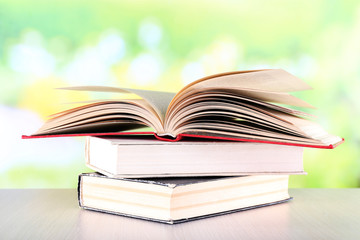 Books on wooden table on natural background
