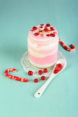 Obraz na płótnie Canvas Cranberry milk dessert in glass jar, on color wooden background
