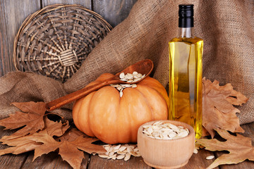 Pumpkin seed oil in glass bottle and fresh pumpkin