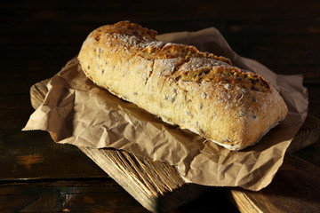White bread on craft paper on cutting board on wooden