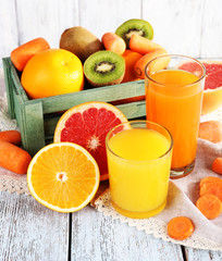 Fruit and vegetable juice in glasses and fresh fruits in box