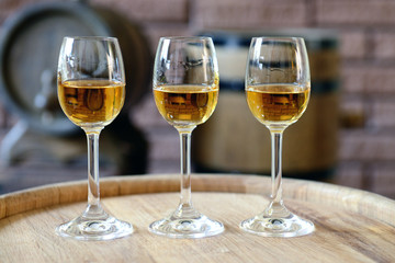 Glasses of wine in cellar with old barrels