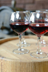 Glasses of wine in cellar with old barrels