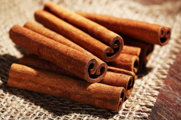 Cinnamon sticks on sackcloth on table close up