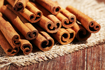 Cinnamon sticks on sackcloth on table close up