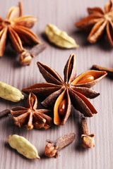 Stars anise with cardamom and carnation on wooden background