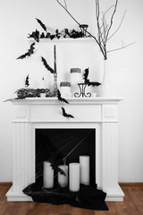 Halloween composition on fireplace in room