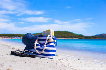 Obraz premium Blue bag, straw hat, flip flops and towel on white tropical