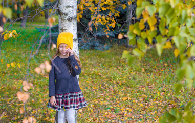 Adorable little girl at beautiful autumn day outdoors
