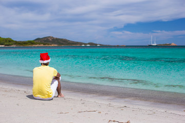 Young man in santa hat during beach vacation