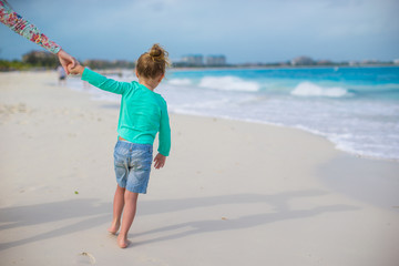 Adorable little girl at white beach during summer vacation