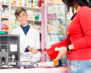 Fototapeta na wymiar Customer paying with credit card in pharmacy