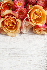 Pastel pink roses on wooden background