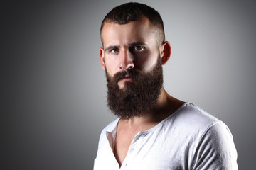 Portrait of handsome bearded man standing, isolated on grey