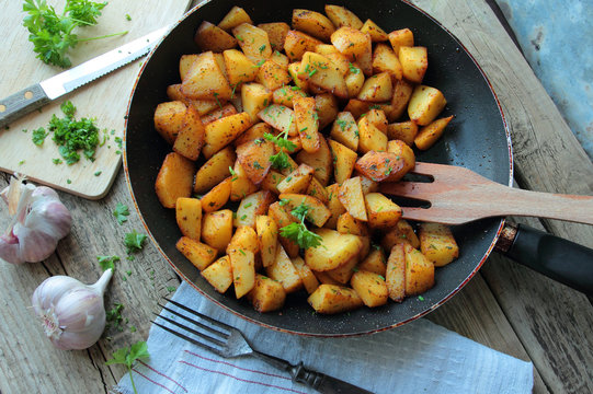 Fresh fried potatoes chips on a pan with herbs