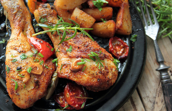 Roasted chicken legs with fresh herbs and fried potatoes