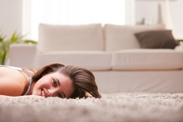 Obraz na płótnie Canvas happy girl on the carpet in her living room